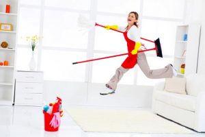 Happy cleaning lady jumping after finishing a housework