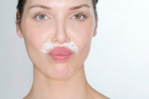 Woman bleaching facial hair