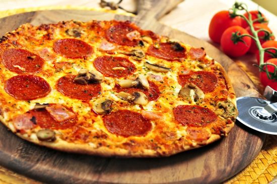 Freshly baked pepperoni pizza on wooden board